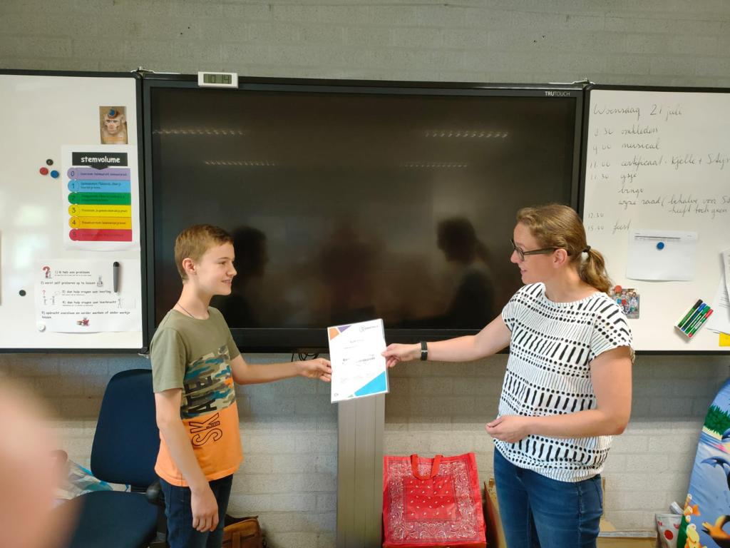 Sylvia Paffen reikt het certificaat uit aan Kjelle