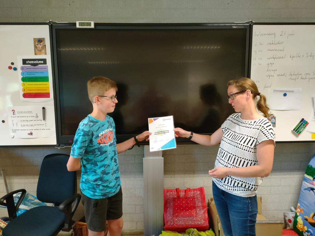 Sylvia Paffen reikt het certificaat uit aan Stijn