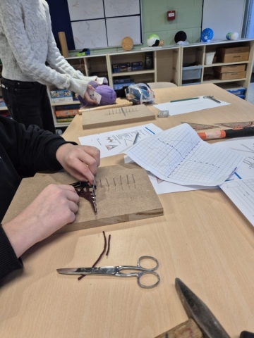 Leerlingen concentreren zich op het spannen van de rechte lijnen om een curve te maken.